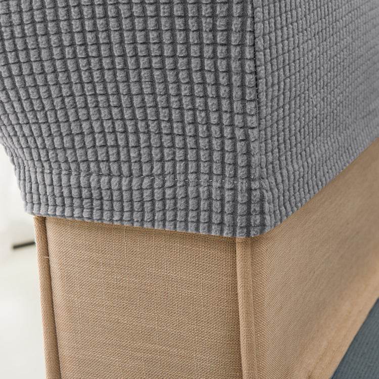Close-up of textured gray fleece fabric snugly covering a sofa armrest, highlighting the soft, protective fit of the Cozee Timeless Arm Cover for everyday comfort and spill protection