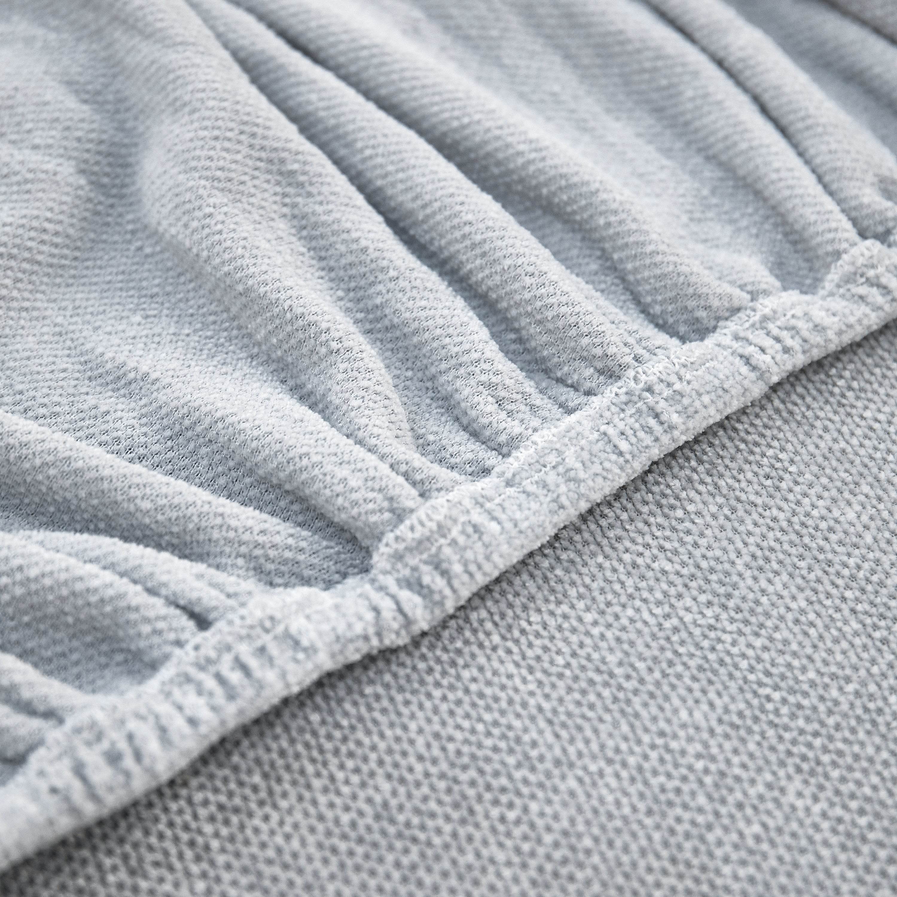 Close-up of reinforced stitching along the edge of the chenille slipcover, showing quality craftsmanship and durability