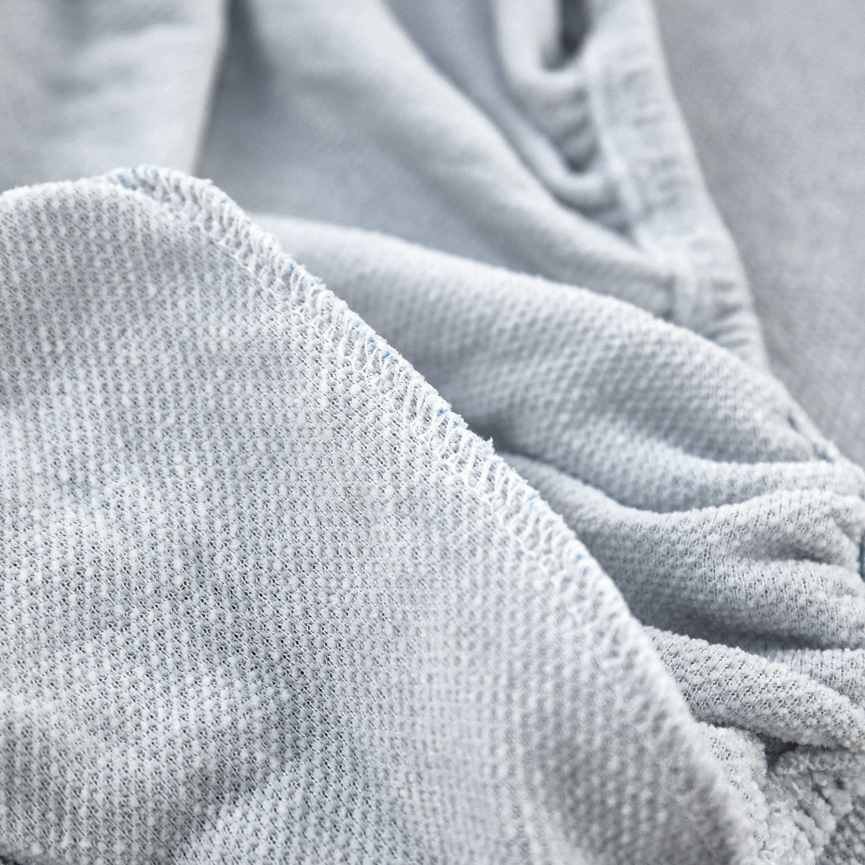 Close-up of reinforced stitching along the edge of chenille slipcover for added durability