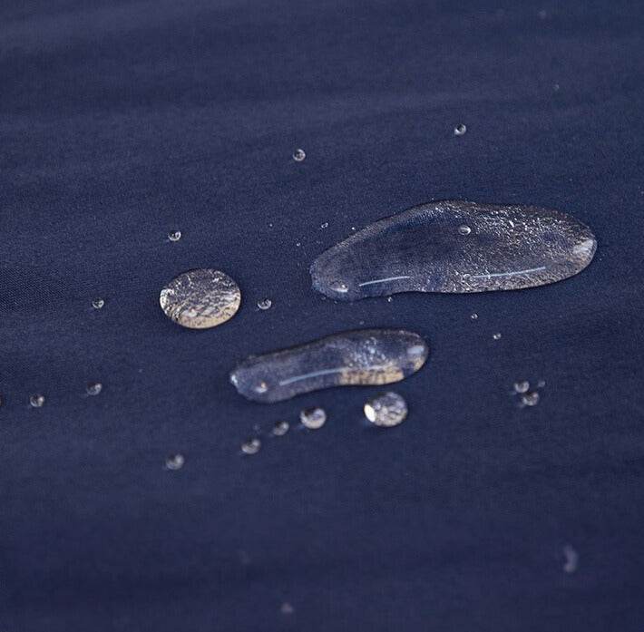 Close-up of water droplets beading on the surface of the Cozee Comfort Guard Slipcover, demonstrating its water-resistant fabric that helps protect against spills and stains