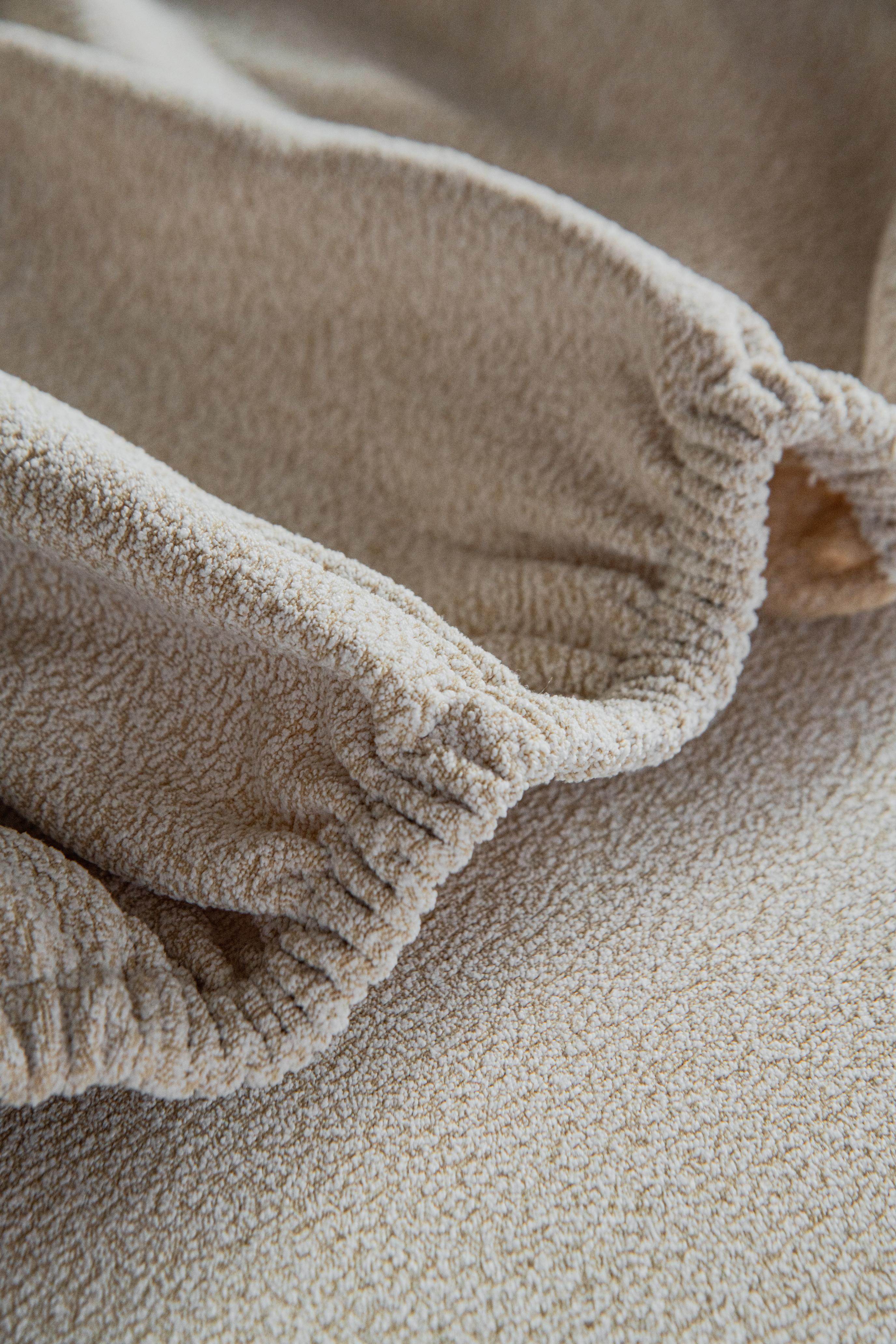 Close-up of the Cozee Cozura Sofa Cover seams, showing reinforced stitching and durable construction for long-lasting use.