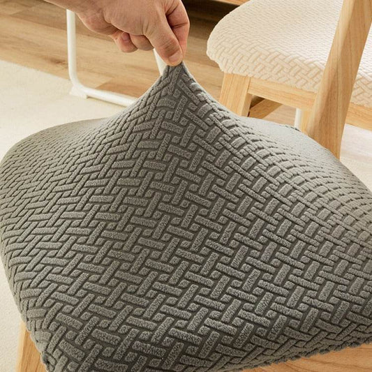 Close-up of textured gray fabric draped over a chair seat, highlighting the soft, durable stretch material used in the Cozee Elastic Seat Cover for a modern and protective finish