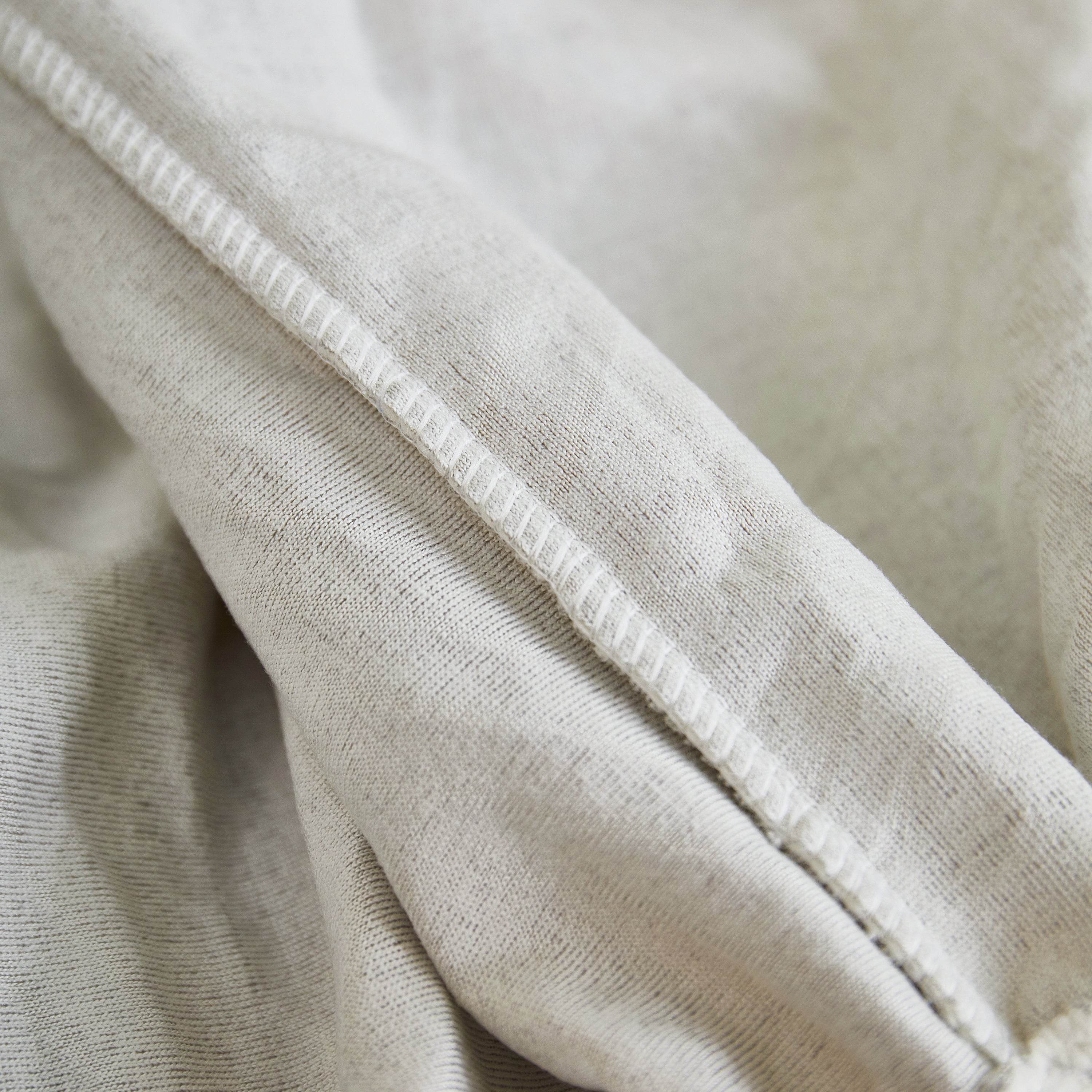 Close-up of the Cozee Herringbone Sofa Cover showing reinforced seams and durable stitching for a snug, long-lasting fit.