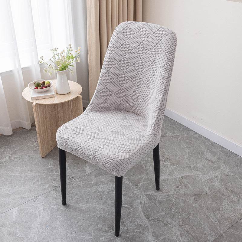 Dining chair covered with the Cozee Jacquard Curved Chair Cover, featuring a refined jacquard texture and flexible stretch fit that hugs curved backs for a sleek, elegant look and everyday protection