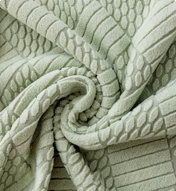 Close-up of textured mint green jacquard fabric with an intricate woven pattern, highlighting the elegant detail and premium finish of the Cozee Curved Chair Cover