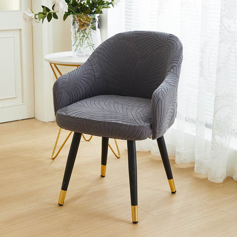 Full coverage chair cover with ultra-soft stretch velvet fabric, designed to fit curved-back chairs with high armrests and featuring an elegant embossed leaf pattern