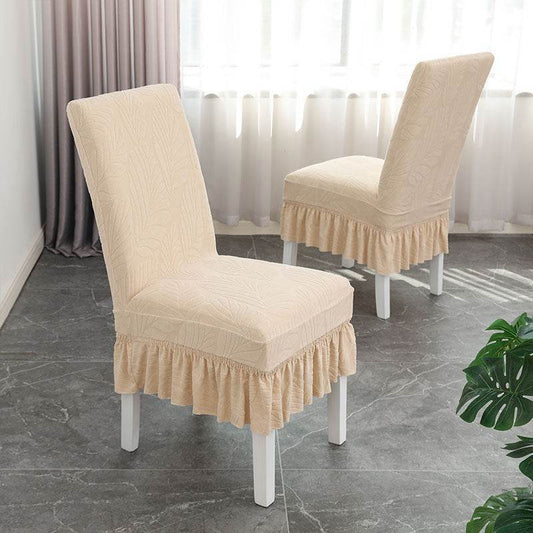 Dining chair fully covered with the Cozee SoftWeave Skirted Chair Cover, featuring a snug stretch fit and elegant skirt that hides chair legs while offering breathable comfort and full protection