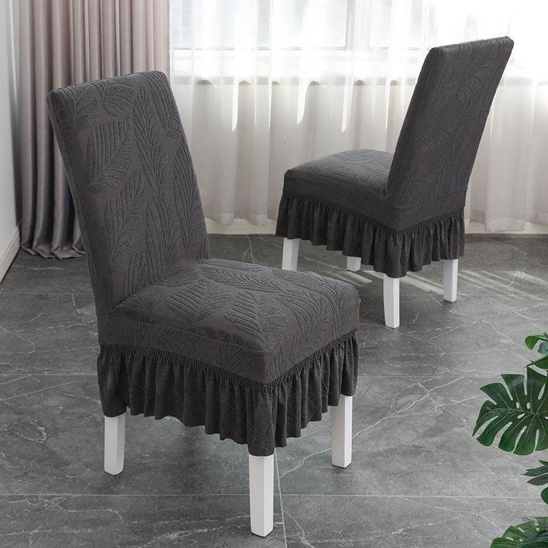 Dining chair fully covered with the Cozee SoftWeave Skirted Chair Cover, featuring a snug stretch fit and elegant skirt that hides chair legs while offering breathable comfort and full protection