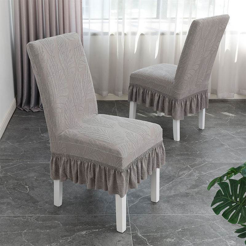 Dining chair fully covered with the Cozee SoftWeave Skirted Chair Cover, featuring a snug stretch fit and elegant skirt that hides chair legs while offering breathable comfort and full protection