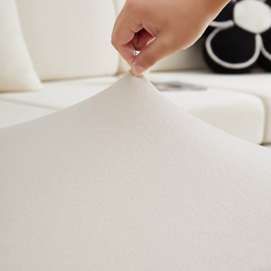 Close-up of a hand touching soft cream teddy fleece fabric—highlighting the cozy, textured surface of this stretch-fit couch and sofa cover.