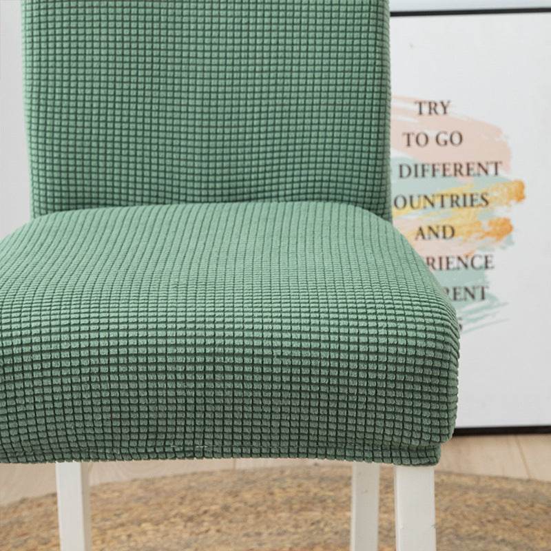 Close-up of a mint green chair covered in plush fleece fabric, highlighting the soft texture and stretchable material of the Cozee Timeless Chair Cover