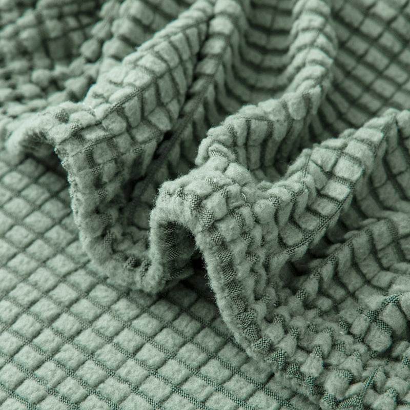 Close-up of mint fleece chair cover being stretched, showcasing the high-elasticity fabric and snug fit of the Cozee Timeless Chair Cover for secure, all-around coverage
