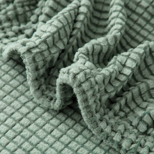 Close-up of mint fleece chair cover being stretched, showcasing the high-elasticity fabric and snug fit of the Cozee Timeless Chair Cover for secure, all-around coverage