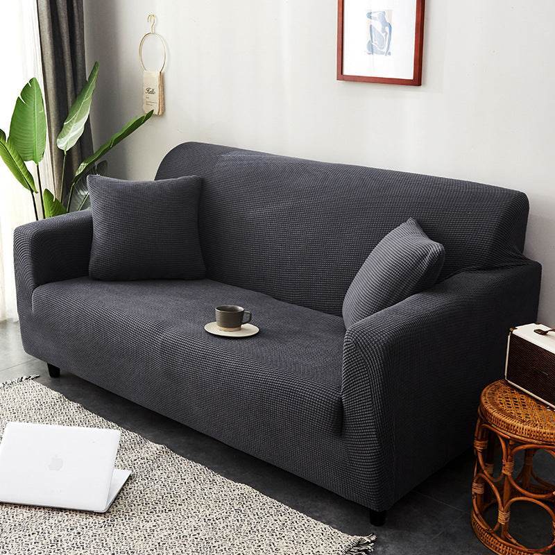 Full view of a sofa covered with the Cozee Timeless Slipcover, styled with matching cushions in a cozy living room setting, showcasing the soft plush fabric and snug fit for a warm, inviting look