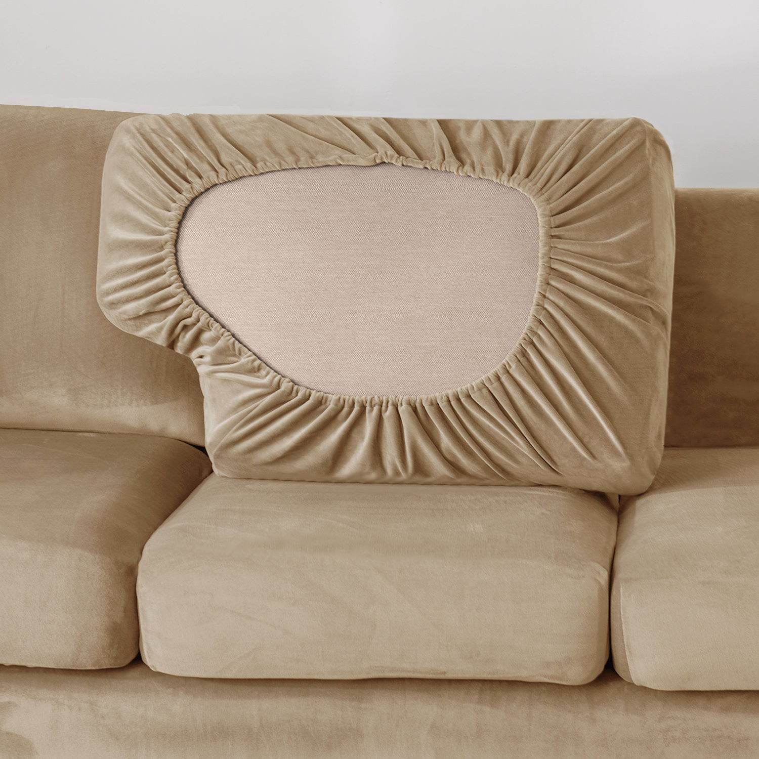 Beige sofa with a fitted velvet slipcover on the backrest, showing a smooth, tailored look and full coverage for protection and style
