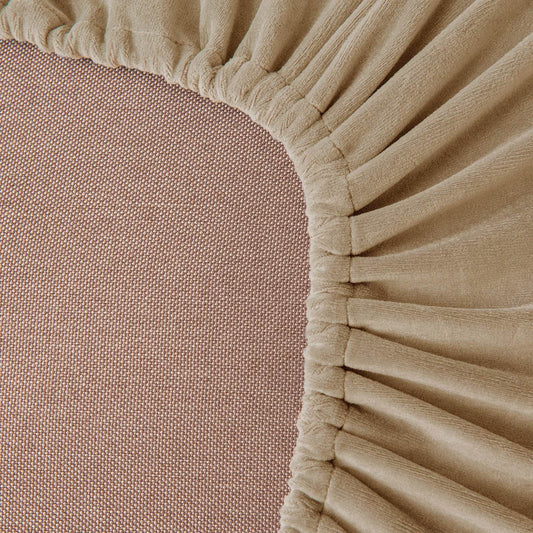 Close-up of beige velvet slipcover fabric with a soft, textured surface, highlighting the plush feel and premium quality of the Cozee Stretch Set