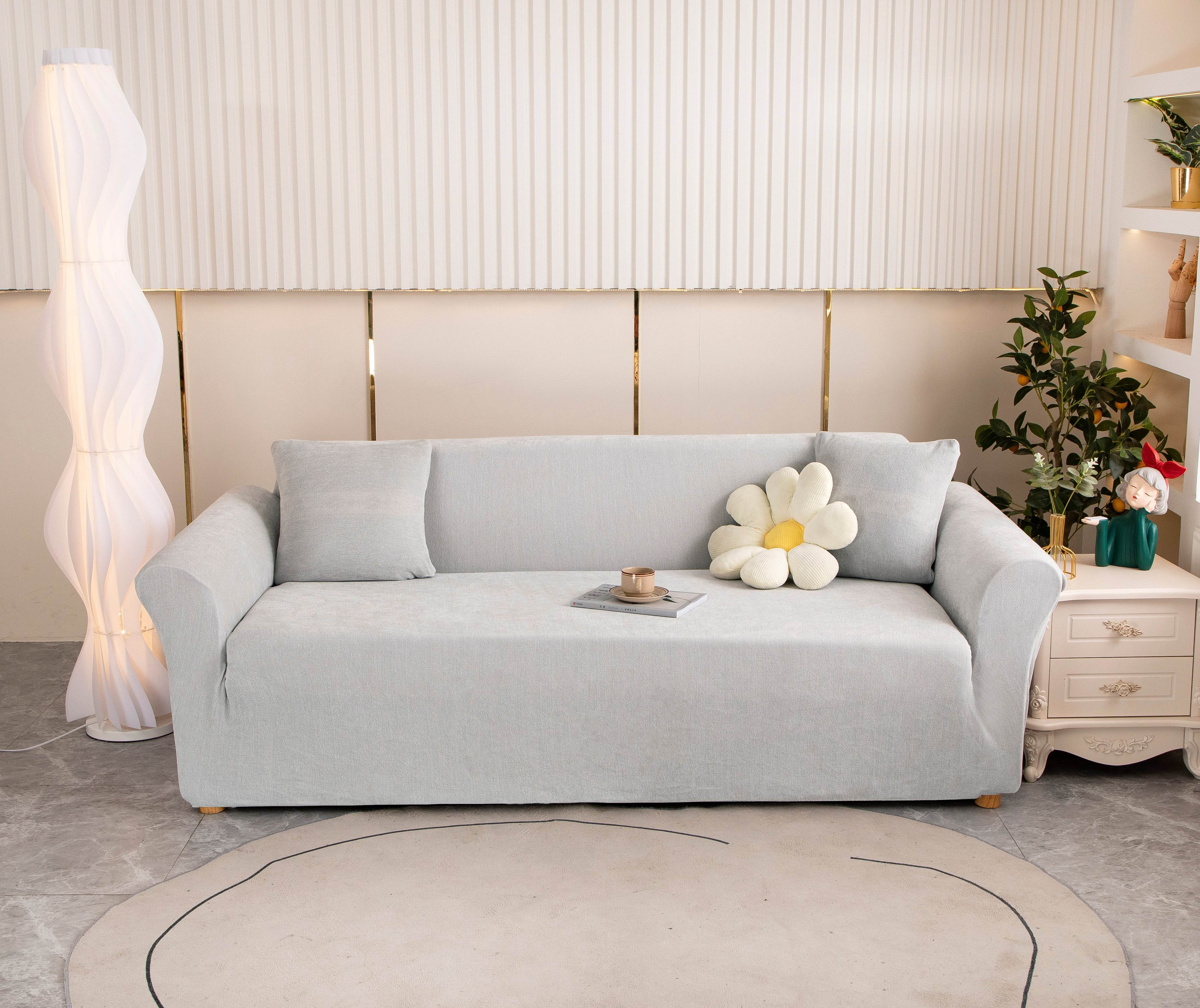 Full view of light gray Cozee Chenille slipcover fitted on a 3-seater sofa in a bright living room